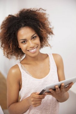 Gülümseyen mutlu afro Amerikan kadın evde PC tablet kullanma.