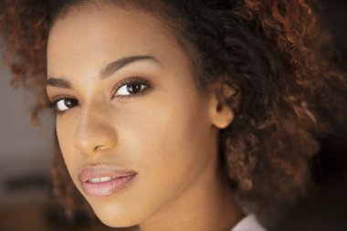 Young cheerful woman smiling  to a camera at home.