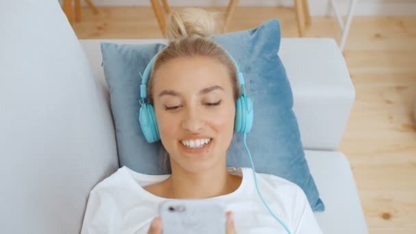 Młoda Kobieta Smartfonem Słuchawkami Domu — Wideo stockowe