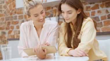 Evdeki mutfakta dijital tablet kullanan iki güzel kadın..