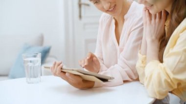 Evdeki mutfakta dijital tablet kullanan iki güzel kadın..