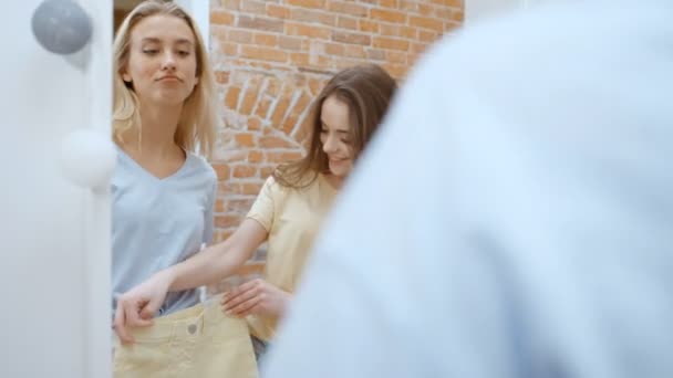 Två Glada Vackra Unga Kvinnor Som Försöker Kläder — Stockvideo