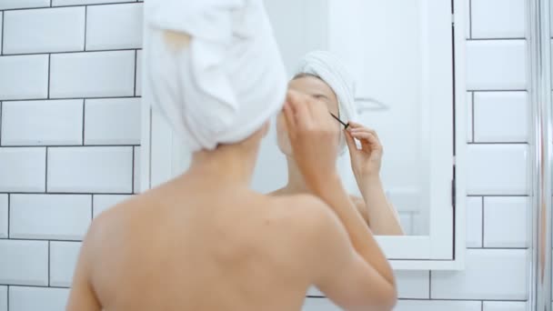 Giovane Donna Allegra Utilizzando Mascara Fronte Uno Specchio — Video Stock