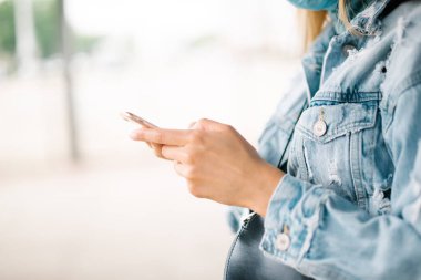 Şehir parkında akıllı bir telefon kullanarak kadın ellerini kapat..