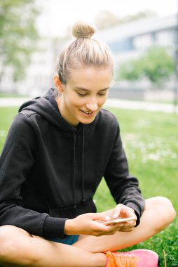 Şehir parkında telefon kullanan çekici bir kadın..