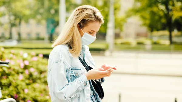 Young Blonde Woman Wearing Mask Waiting Bus Station Using Phone — Stock Photo, Image