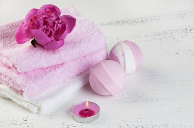 Banyo bombalar, pembe şakayık, havlu ve aroma mum eski püskü beyaz dokulu arka plan üzerinde beyaz Spa kompozisyon pembe. Metin için yer kopyalayın
