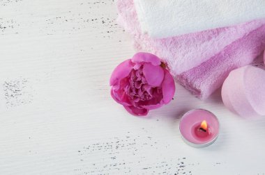 Banyo bombalar, pembe şakayık, havlu ve aroma mum eski püskü beyaz dokulu arka plan üzerinde beyaz Spa kompozisyon pembe. Metin için yer kopyalayın