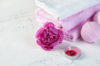Banyo bombalar, pembe şakayık, havlu ve aroma mum eski püskü beyaz dokulu arka plan üzerinde beyaz Spa kompozisyon pembe. Metin için yer kopyalayın