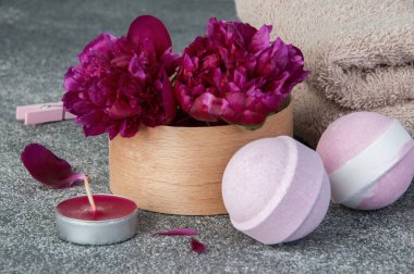 Spa kompozisyon banyo bomba ile bir kutu ve aroma mum, iki peonies gri dokulu arka plan üzerine kapatın. Metin için yer kopyalayın