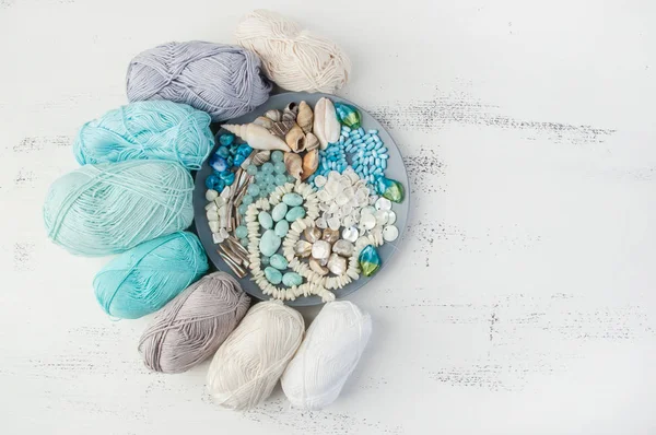 編み物のスレッドとビーズと貝殻が灰色プレート — ストック写真