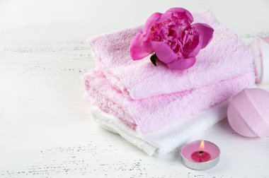 Banyo bombalar, pembe şakayık, havlu ve aroma mum eski püskü beyaz dokulu arka plan üzerinde beyaz Spa kompozisyon pembe. Metin için yer kopyalayın