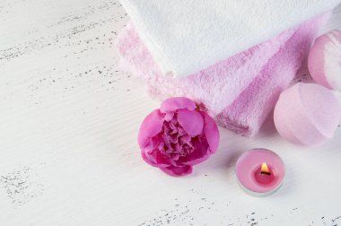 Banyo bombalar, pembe şakayık, havlu ve aroma mum eski püskü beyaz dokulu arka plan üzerinde beyaz Spa kompozisyon pembe. Metin için yer kopyalayın
