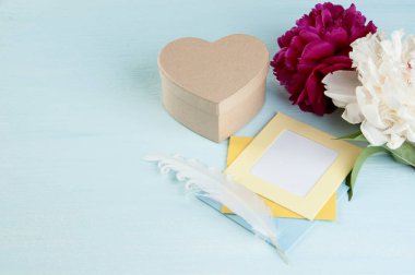 Boş Not, kraft Hediyelik kutu şeklindeki bir kalp ve peonies eski püskü mavi zemin üzerine. Metin için yer kopyalayın.