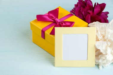 Boş Not, sarı hediye kutusu peonies üzerinde eski püskü mavi arka plan ve yayla. Metin için yer kopyalayın.