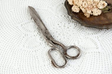 Eski vintage makas ve vintage metal plaka ile kuru gül beyaz tığ işi bardak altlığı peçete üzerinde. Cpace metin kopyalama.