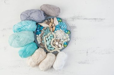 Konu ve boncuk ve kabukları üzerinde eski püskü Beyaz ahşap arka plan gri plaka örgü. Metin için yer kopyalayın.