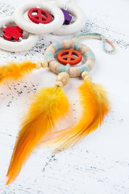 Parlak multi dreamcatcher turuncu bir barış işareti ve turuncu sarı tüyleri beyaz eski püskü ahşap arka plan üzerinde renkli. Metin için yer kopyalayın.