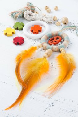 Parlak çok renkli Rüya yakalayıcı turuncu bir barış işareti ve beyaz eski püskü ahşap zemin üzerinde turuncu sarı tüyleri ile. Metin için yer kopyalayın.