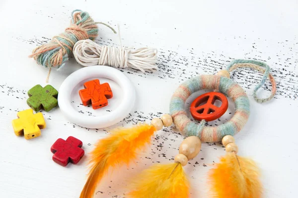 Rüya yakalayıcı turuncu barış işareti ile parlak çok renkli ve beyaz eski püskü ahşap zemin üzerinde turuncu sarı tüyler yakın çekim. Metin için yer kopyalayın.