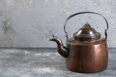Gri beton zemin üzerine antika bakır çaydanlık. metin için Kopyala yer.