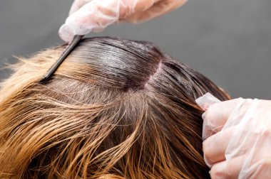 Saç rengi, radikal bir değişim. Sarışın kadın Efendi boya saçları koyar.