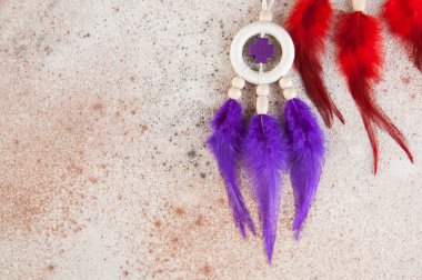 Parlak Rüya yakalayıcı crosse ve beton zemin üzerine kırmızı mor tüyleri ile. Metin için yer kopyalayın.