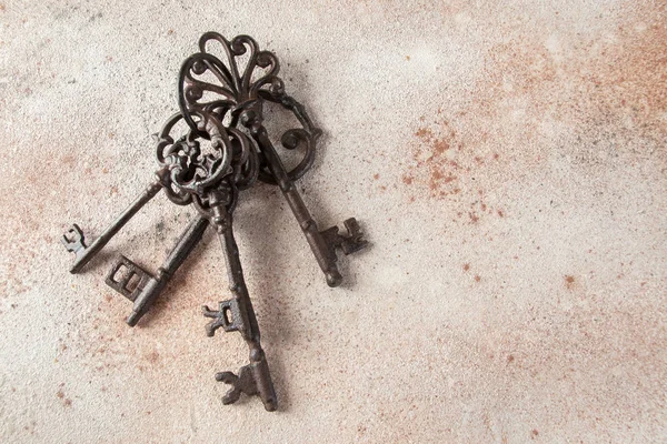 一堆旧的铸铁钥匙在具体的背景上 复制文本空间 — 图库照片