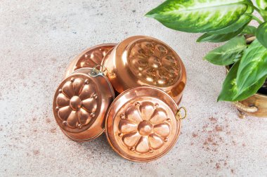 Vintage bakır kek kalıpları ve beton zemin üzerine yeşil bitkiler. Metin için yer kopyalayın