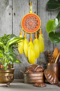 Turuncu sarı Rüya yakalayıcı ve vintage bakır kalıpları iç ahşap gri arka plan üzerinde. Yeşil bitkiler ve metin için yer kopyalayın.