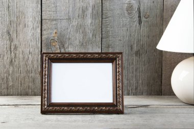 Eski ahşap gri dokulu arka plan boş kahverengi resim çerçeve ve masa lambası. Metin için ev dekorasyonu ve kopya yer.  