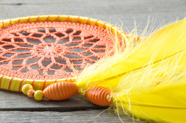 Orange yellow dream catcher on wooden gray background. Copy space for text.