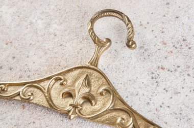 Antika pirinç elbise askısı Fleur de Lis beton zemin üzerine kapatın. Metin için yer kopyalayın.