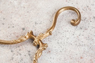 Antika pirinç elbise askısı beton zemin üzerine kapatın. Metin için yer kopyalayın.