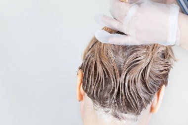 Koyu saç kökleri, aşırı büyümüş saçlar. Saç boyama.