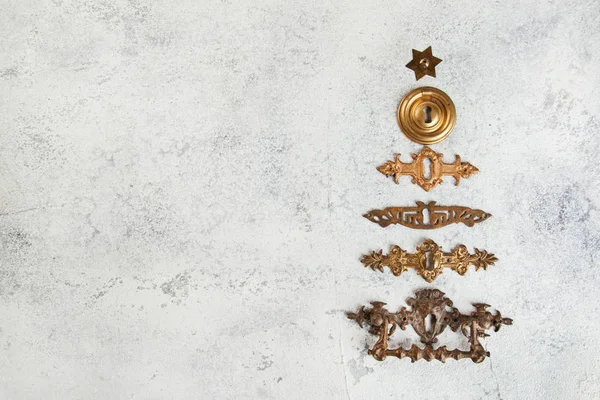 クリスマス ツリーの形に並んでいるビンテージ アンティーク ブロンズ鍵穴カバーをコンクリート背景にクローズ アップ クリスマスの装飾 ストック画像