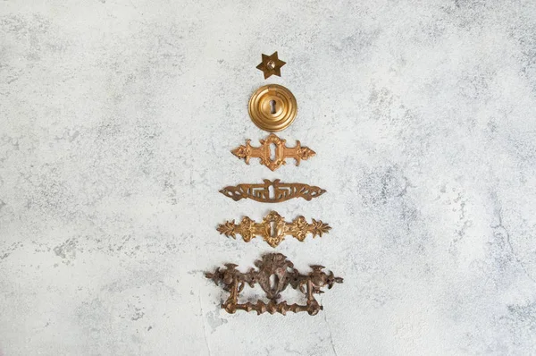 クリスマス ツリーの形に並んでいるビンテージ アンティーク ブロンズ鍵穴カバーをコンクリート背景にクローズ アップ クリスマスの装飾 ストック写真