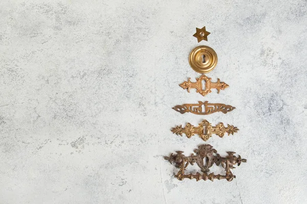 クリスマス ツリーの形に並んでいるビンテージ アンティーク ブロンズ鍵穴カバーをコンクリート背景にクローズ アップ クリスマスの装飾 ロイヤリティフリーのストック写真