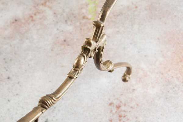 Vintage brass clothes hanger close up on concrete background. Copy space for text.