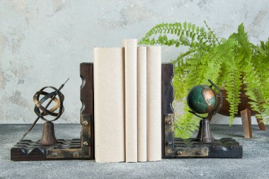 Antique book ends on a gray background clipart