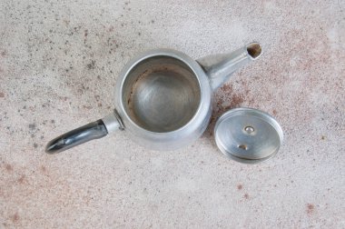 Beton arka plan üzerinde gümüş metal demlik. 