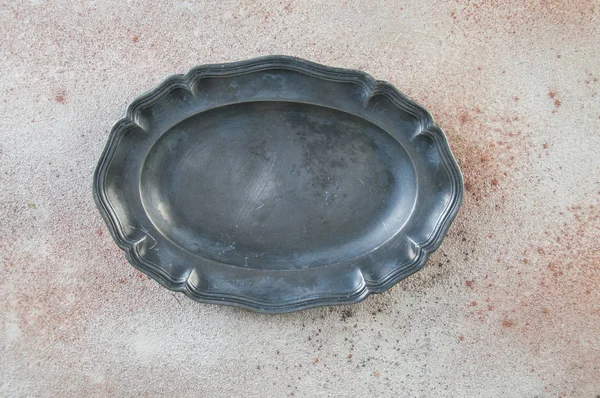 Antický cínové oválný talíř na betonových pozadí. — Stock fotografie