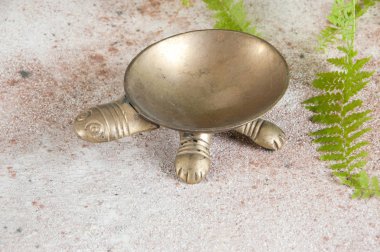 Beton zeminde eski pirinç kül tablası. 