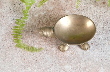 Beton zeminde eski pirinç kül tablası. 