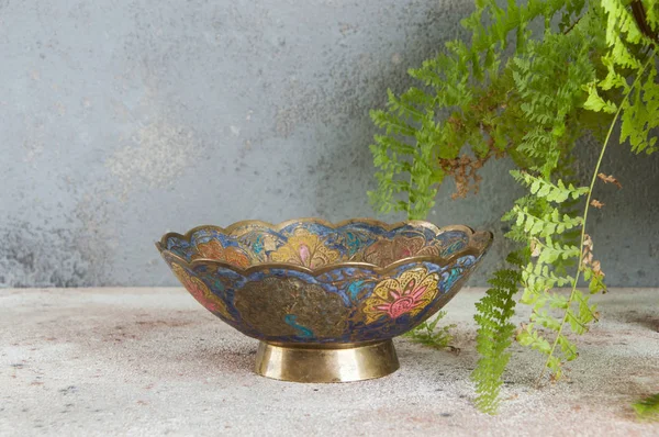 Old brass bowl and green plant