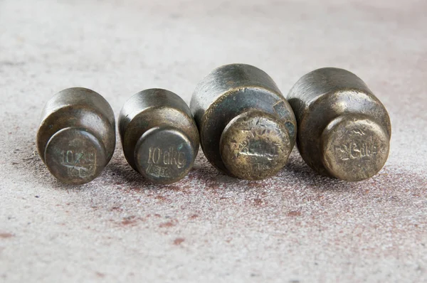 Pesi antichi in bronzo per bilance su fondo di cemento . — Foto Stock