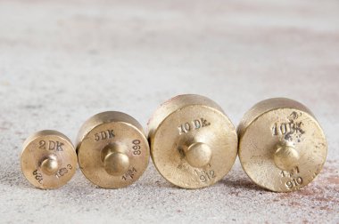 Beton zemin üzerindeki pullar için antika bronz ağırlıklar.