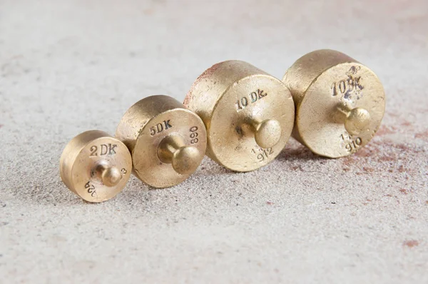 Antique bronze weights for scales on concrete background.