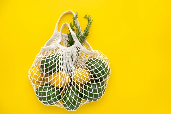 Grocery eco mesh bag with fresh vegetables and herbs. Good and healthy food concept.