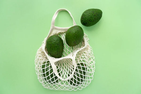 杂货生态网棉袋与鳄梨。素食主义。环保购物和健康生活方式概念. 图库照片